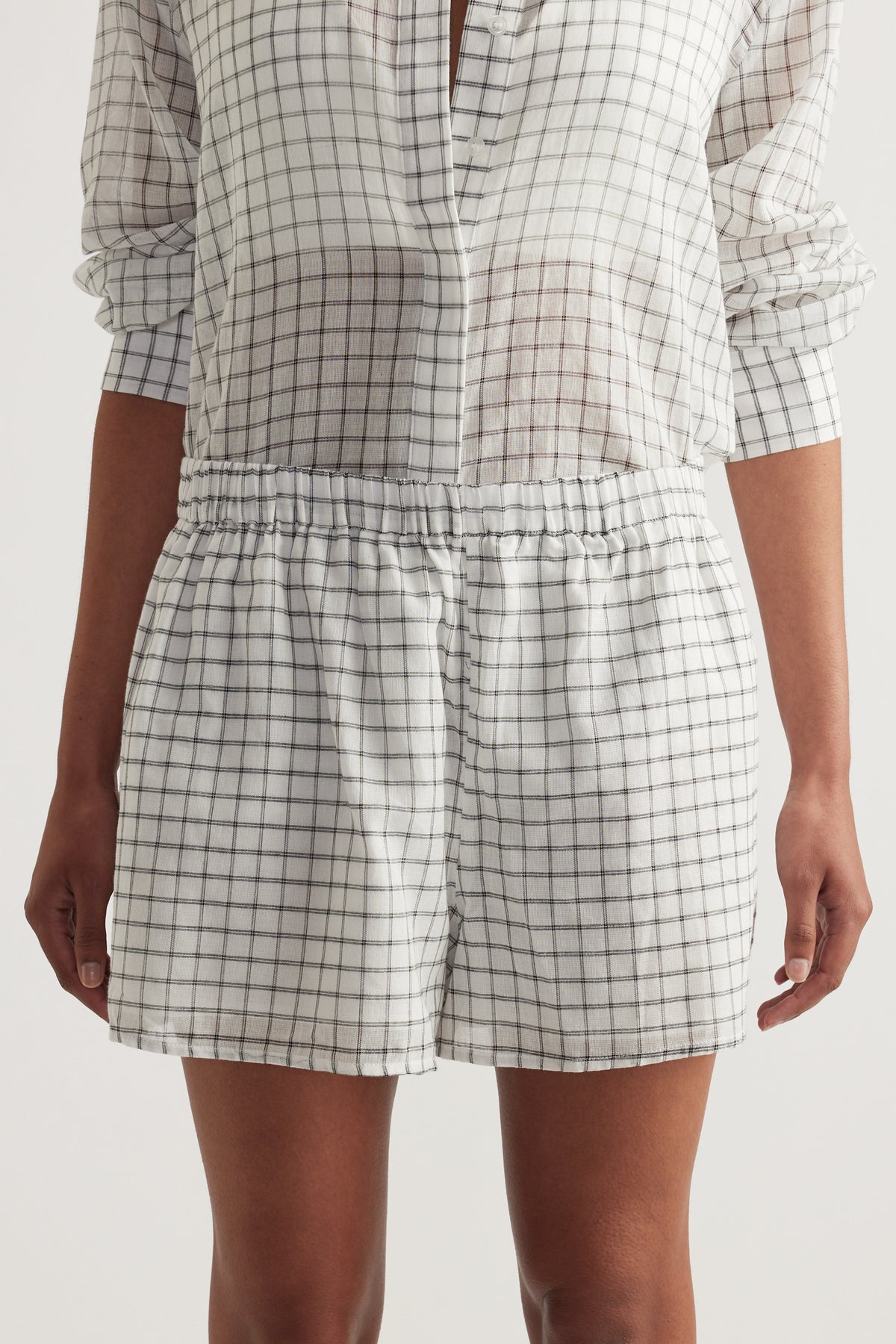 Model wearing lightweight checked shorts with an elasticated waist and matching button up shirt