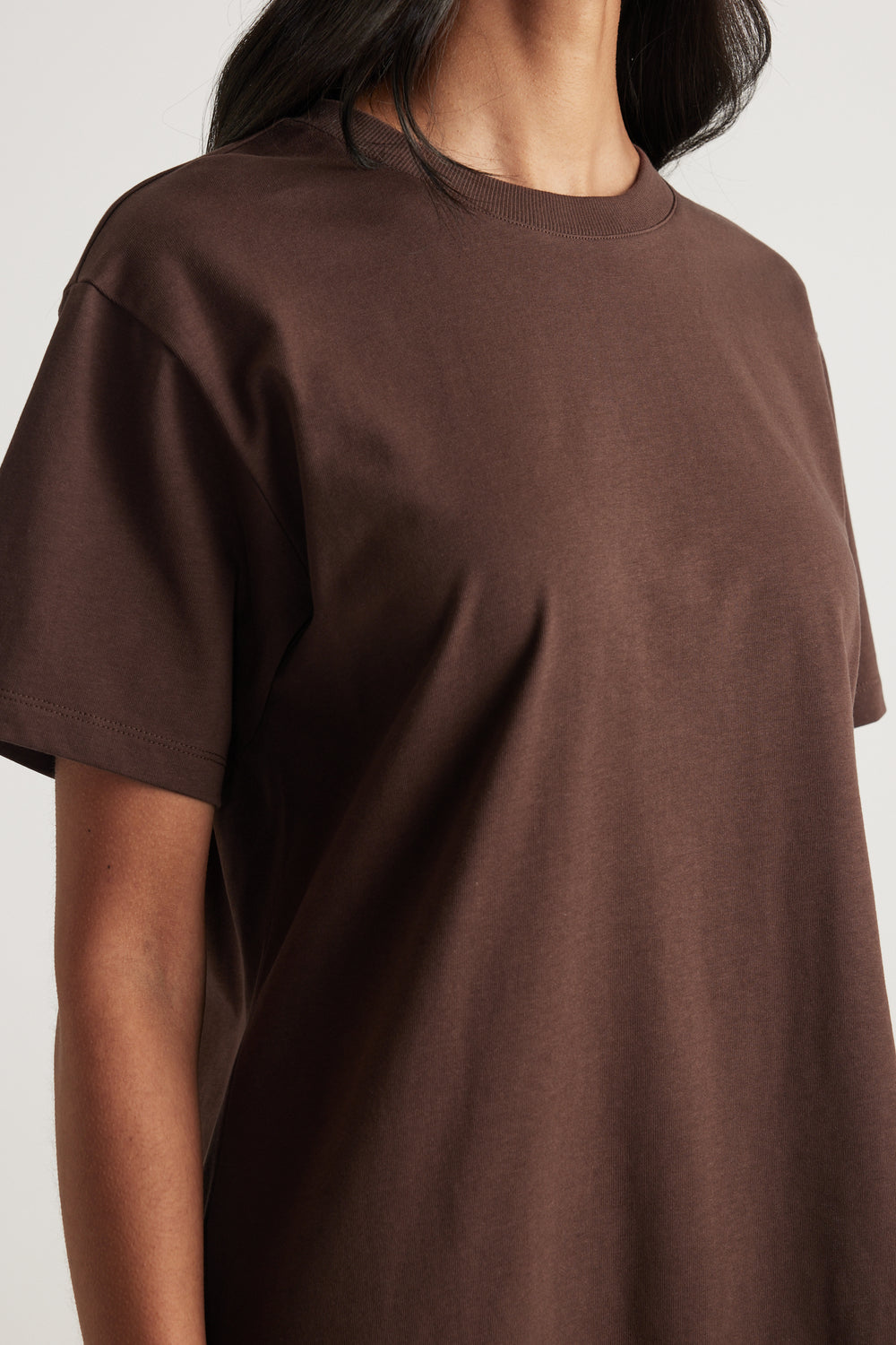 Woman wearing a chocolate brown crew neck short sleeve tee in a relaxed fit
