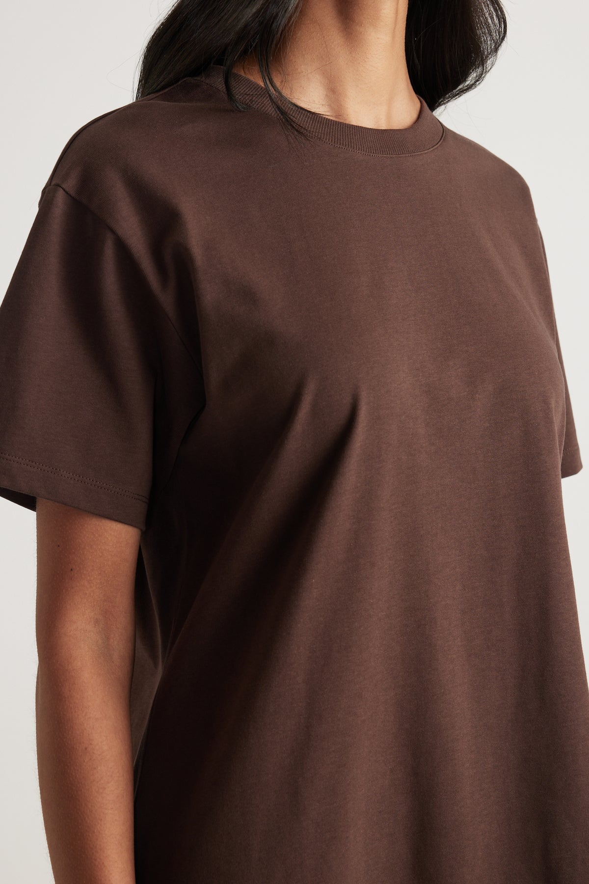 Woman wearing a chocolate brown crew neck short sleeve tee in a relaxed fit