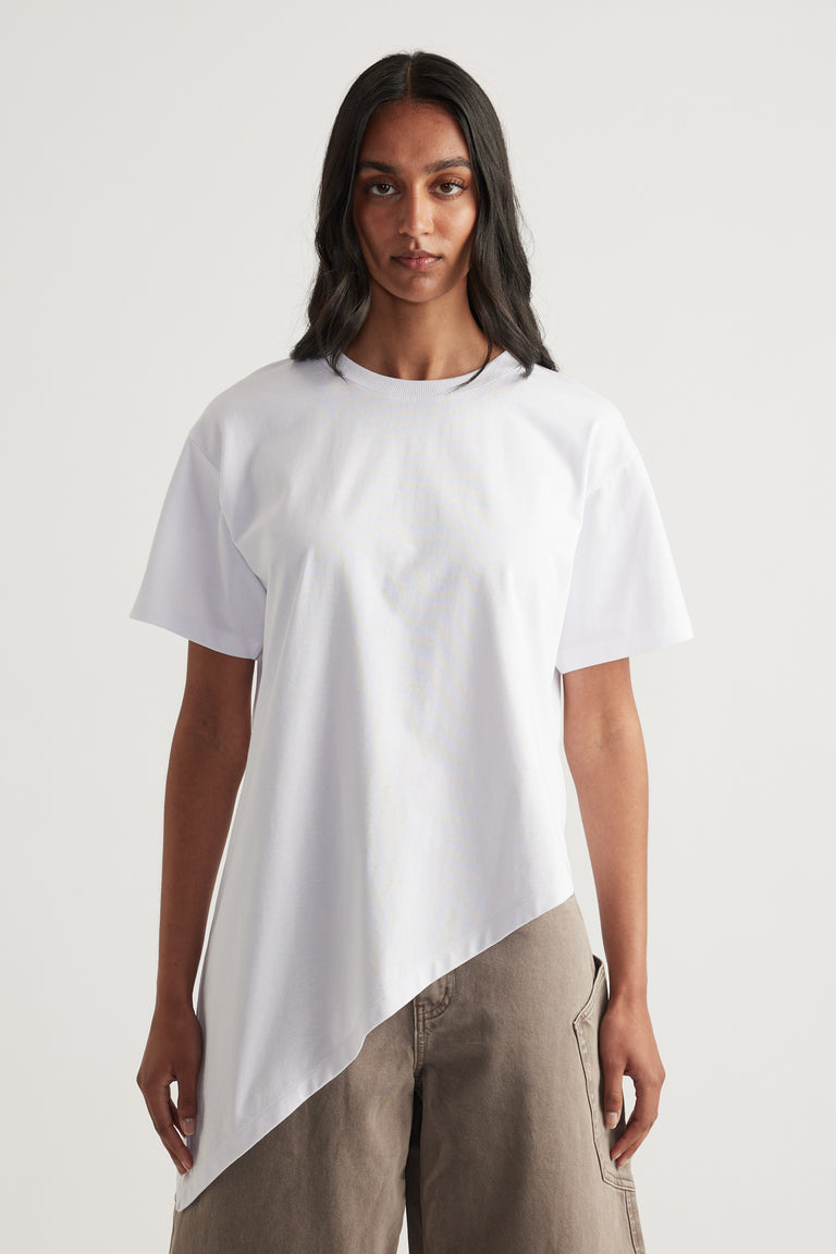 Woman wearing a white crew neck tee with an asymmetric hem and relaxed fit tan jeans