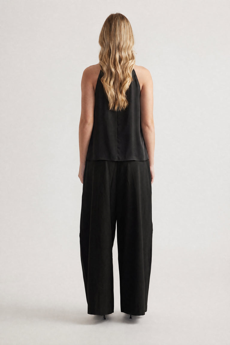 Woman viewed from behind wearing a black halter top with wide leg pants