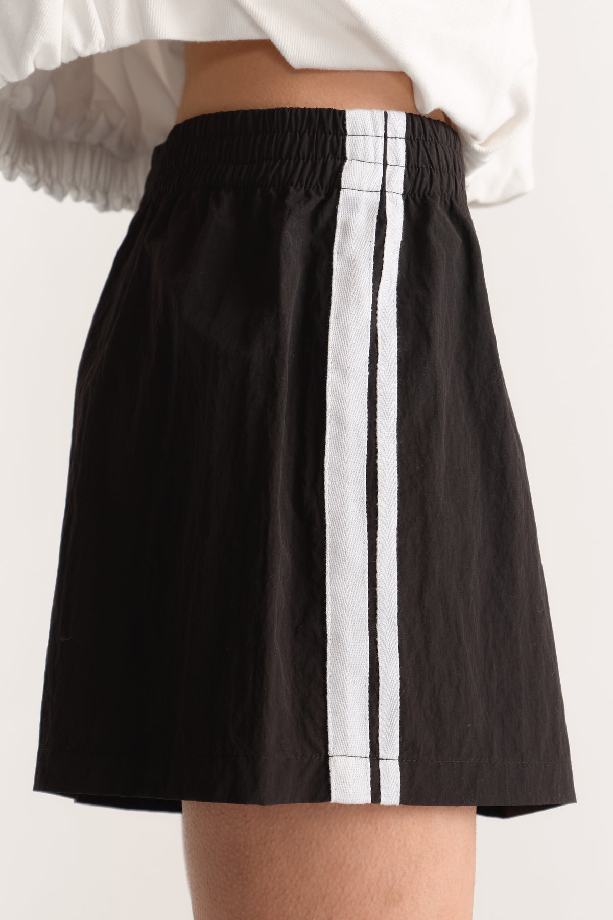 Black shorts with an elasticated waist and contrasting double white side stripe