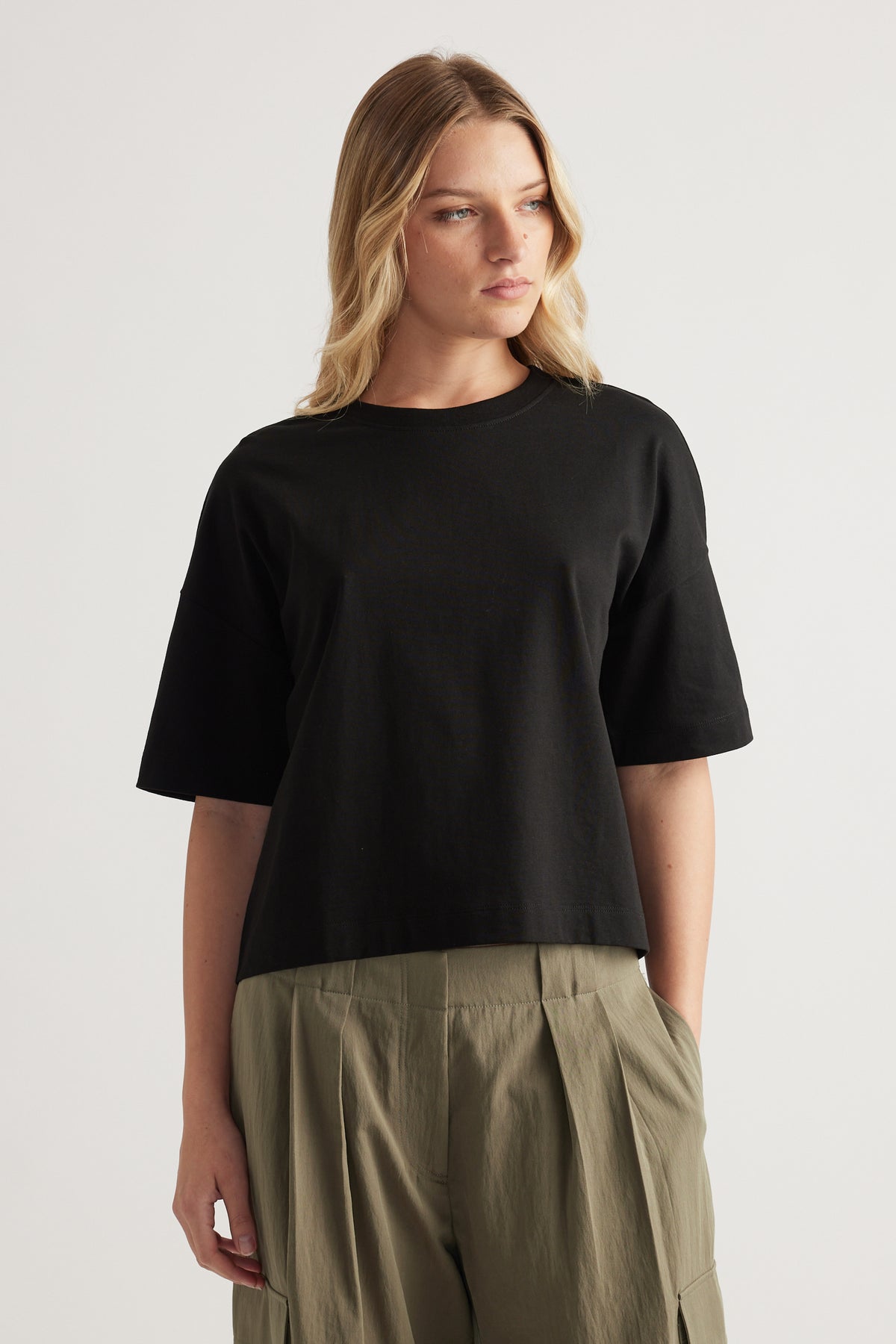 Woman wearing a black cropped boxy tee with olive wide leg pants