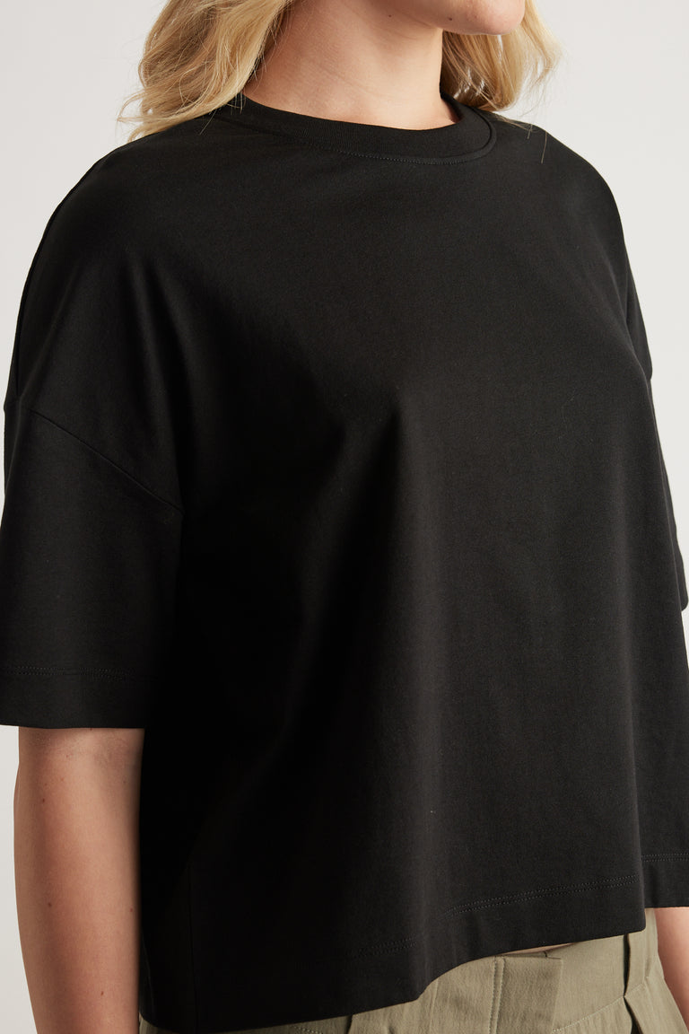 Woman wearing a black cropped boxy crew neck tee with short sleeves
