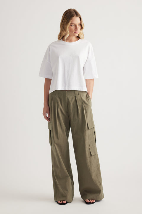 Woman wearing a white cropped boxy tee with olive green cargo pants