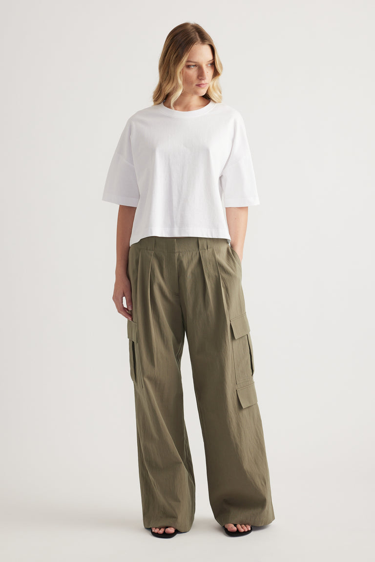 Woman wearing a white cropped boxy tee with olive green cargo pants