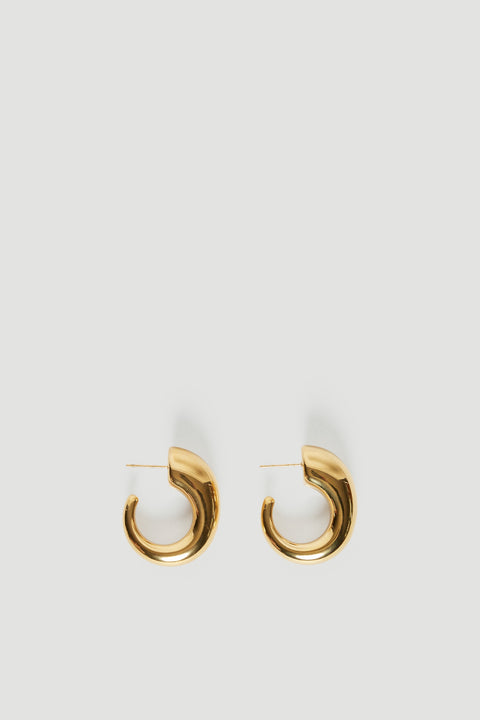 Pair of chunky gold half moon hoop earrings on a light background