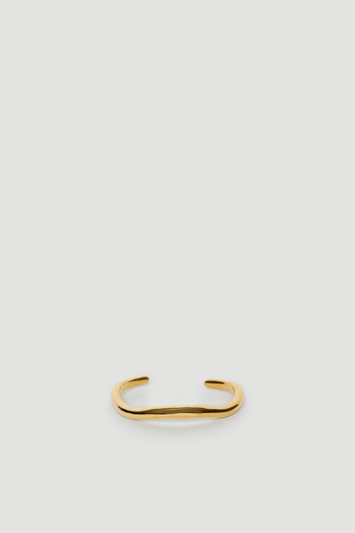 18ct gold molten cuff bangle on a neutral background