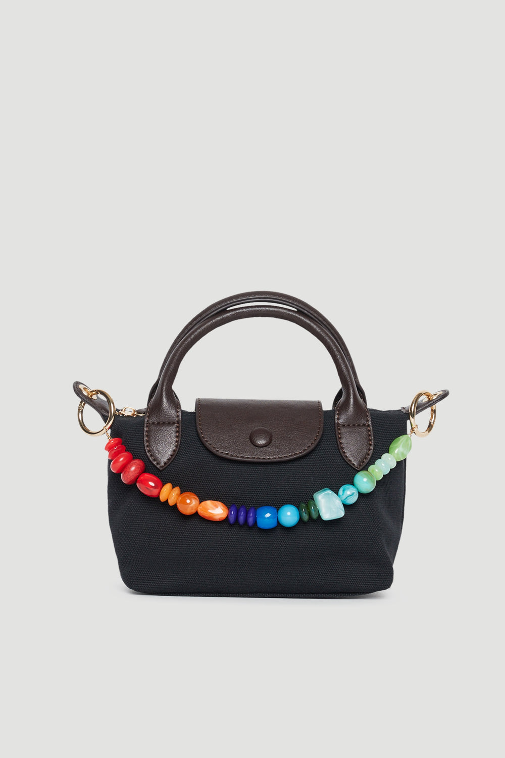 Black handbag with a colourful beaded charm clipped to the handles