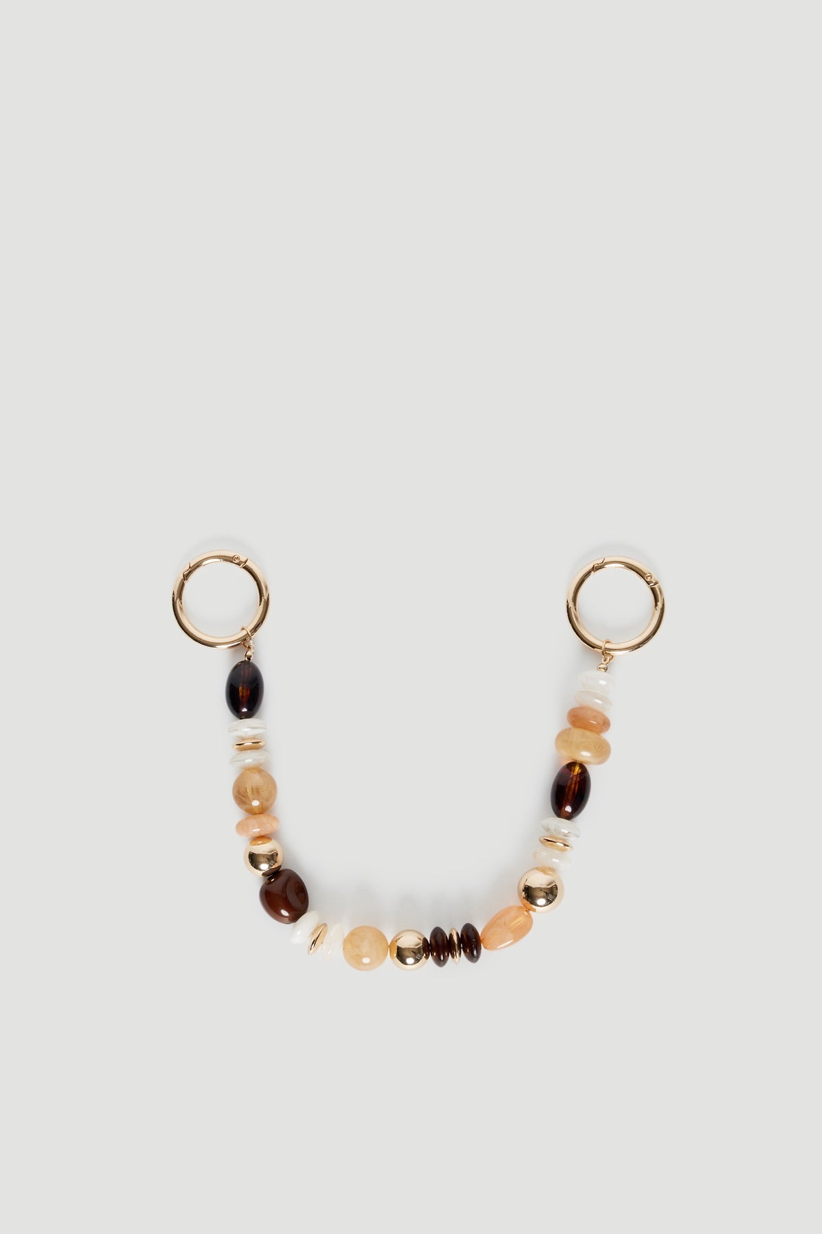 Beaded bag charm with amber, brown and cream beads and gold ring attachments