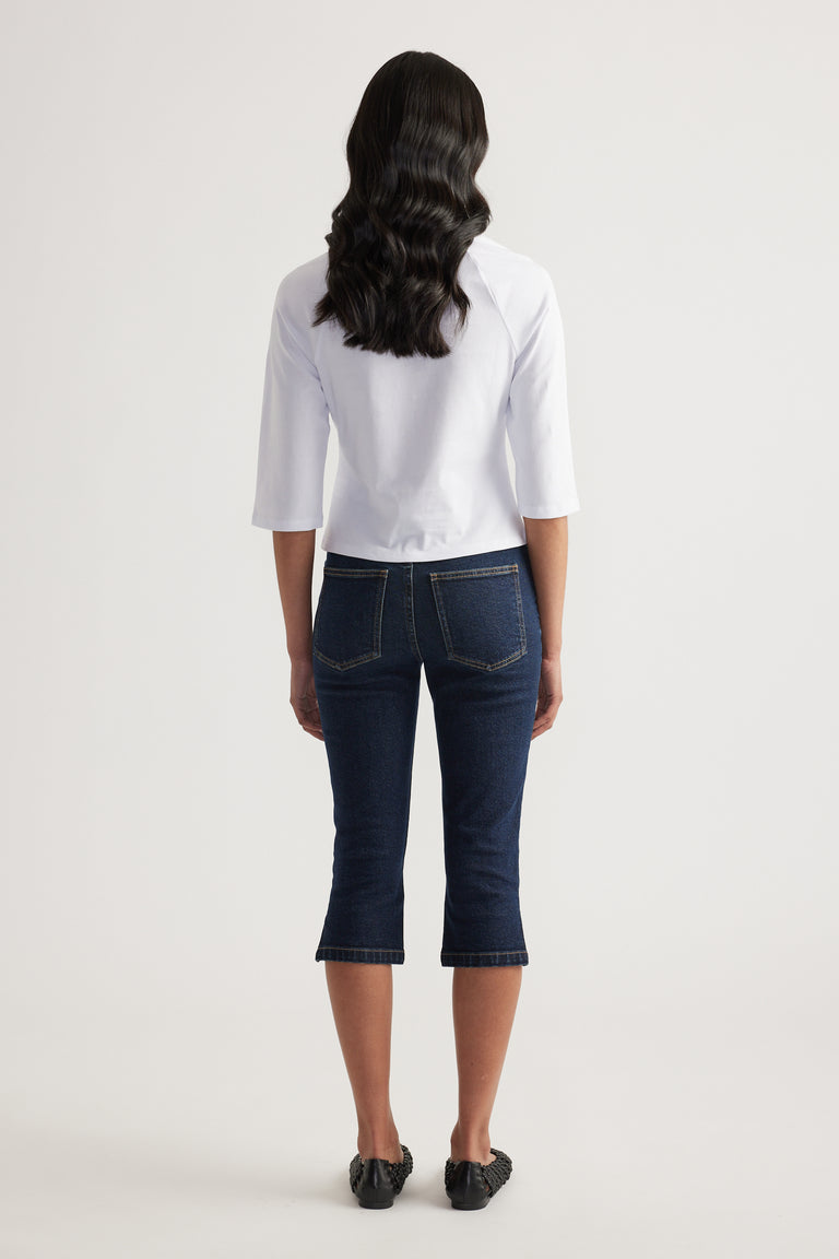 Woman wearing a white fitted three quarter sleeve tee with dark cropped jeans