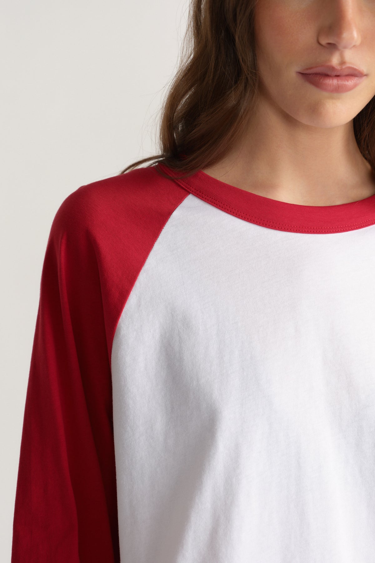 Woman wearing a white and red raglan long sleeve tee with a relaxed fit