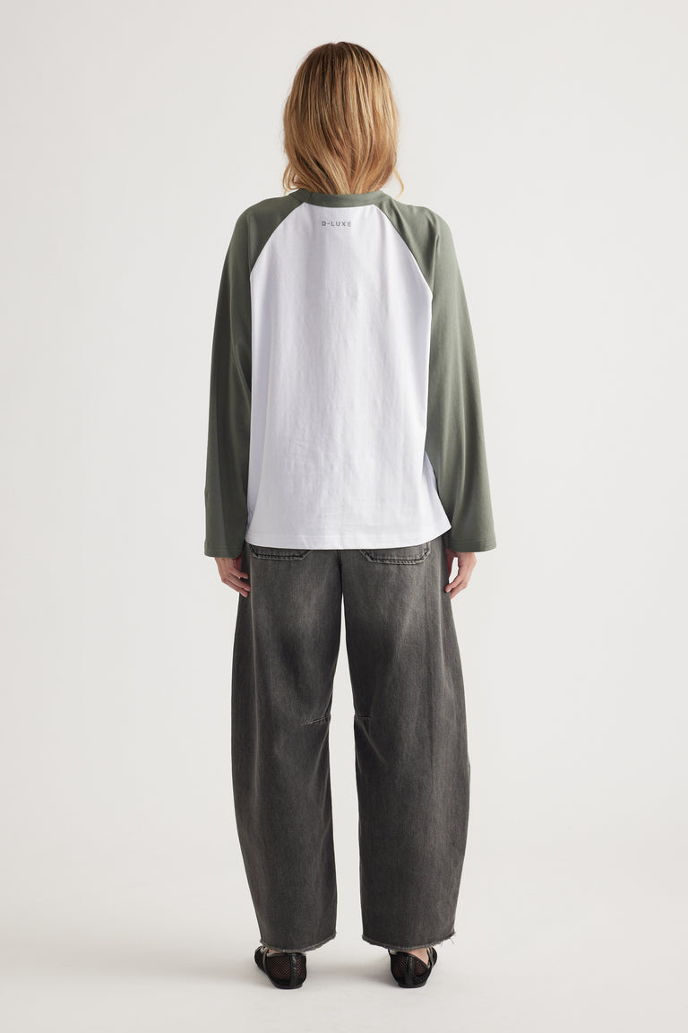 Woman wearing long sleeve baseball tee with contrast sleeves and relaxed dark washed wide-leg jeans, viewed from back