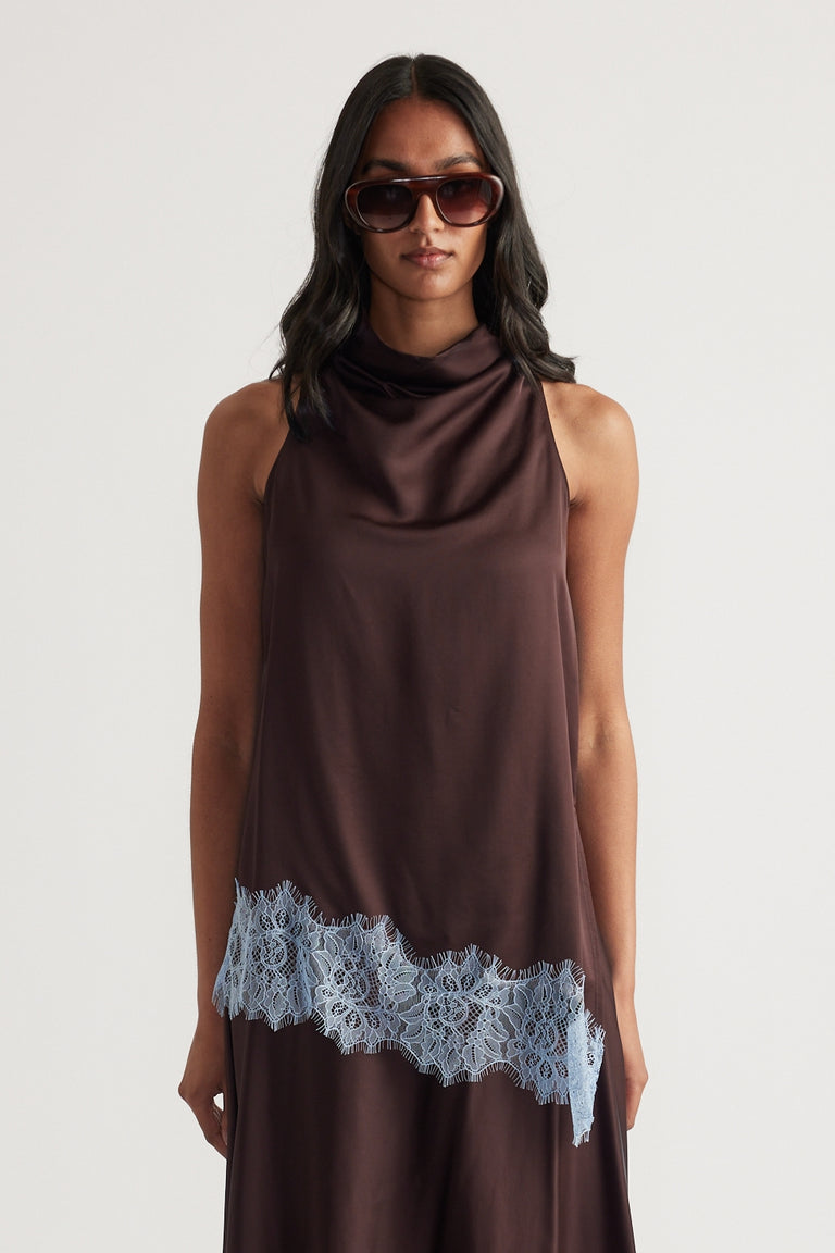 Woman wearing a chocolate brown sleeveless cowl neck top with lace trim asymmetric hem and sunglasses