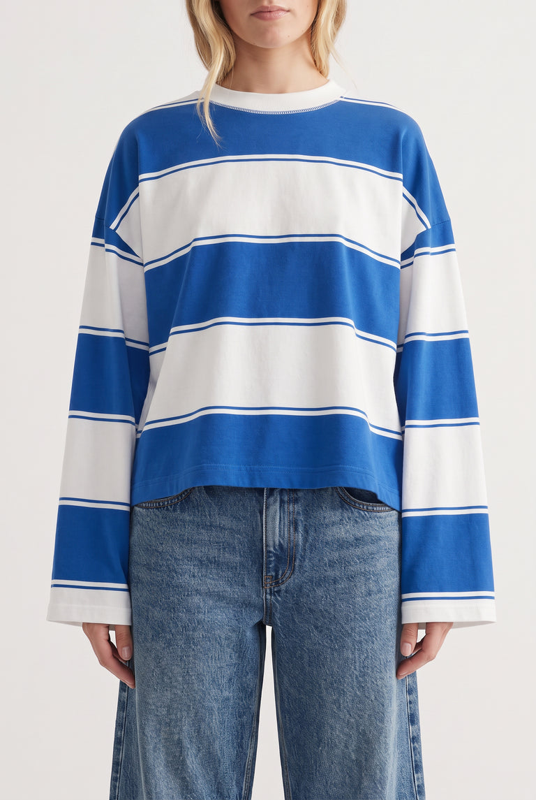 Casual long sleeve tee with bold blue and white wide stripes paired with relaxed fit blue denim jeans.
