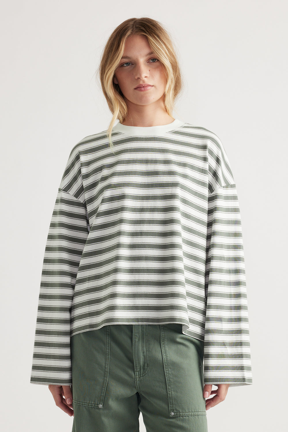Relaxed fit long sleeve tee with green and white horizontal stripes and drop shoulder styling on model