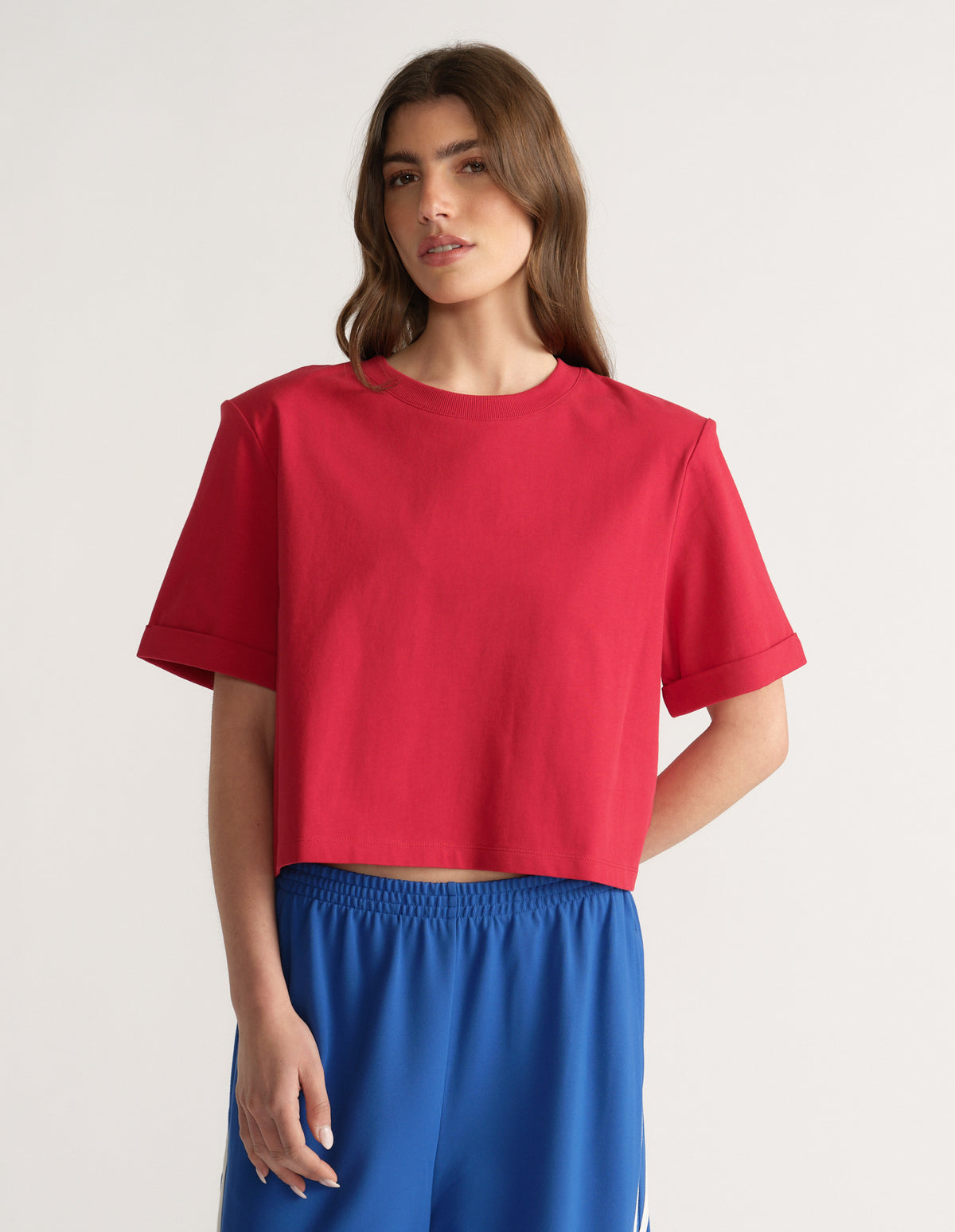 Woman wearing a red padded shoulder tee with blue elastic waist pants