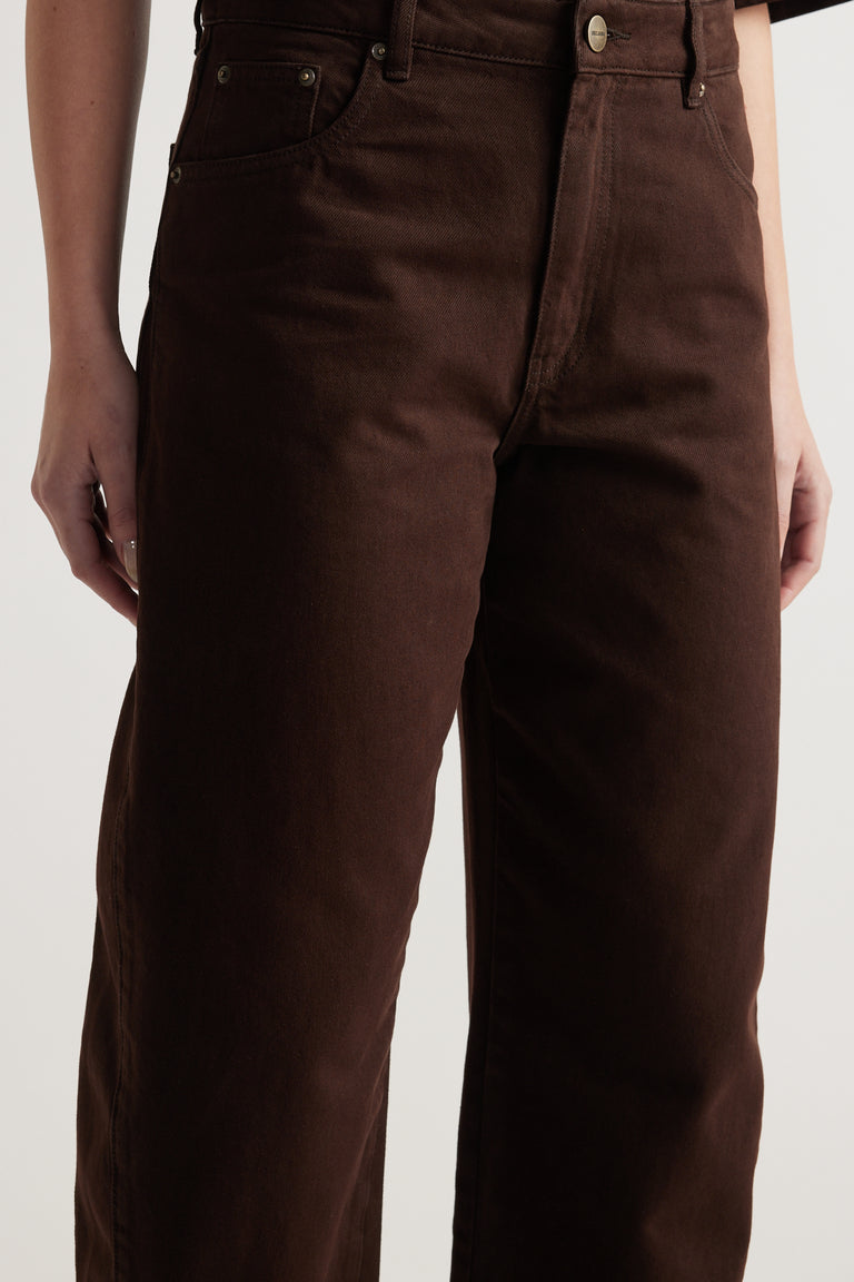 Close-up of a model wearing high-rise dark brown barrel leg jeans
