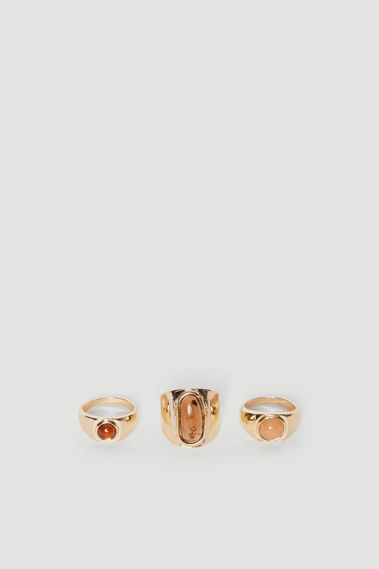 Three gold-tone rings with brown stones and ribbed sides
