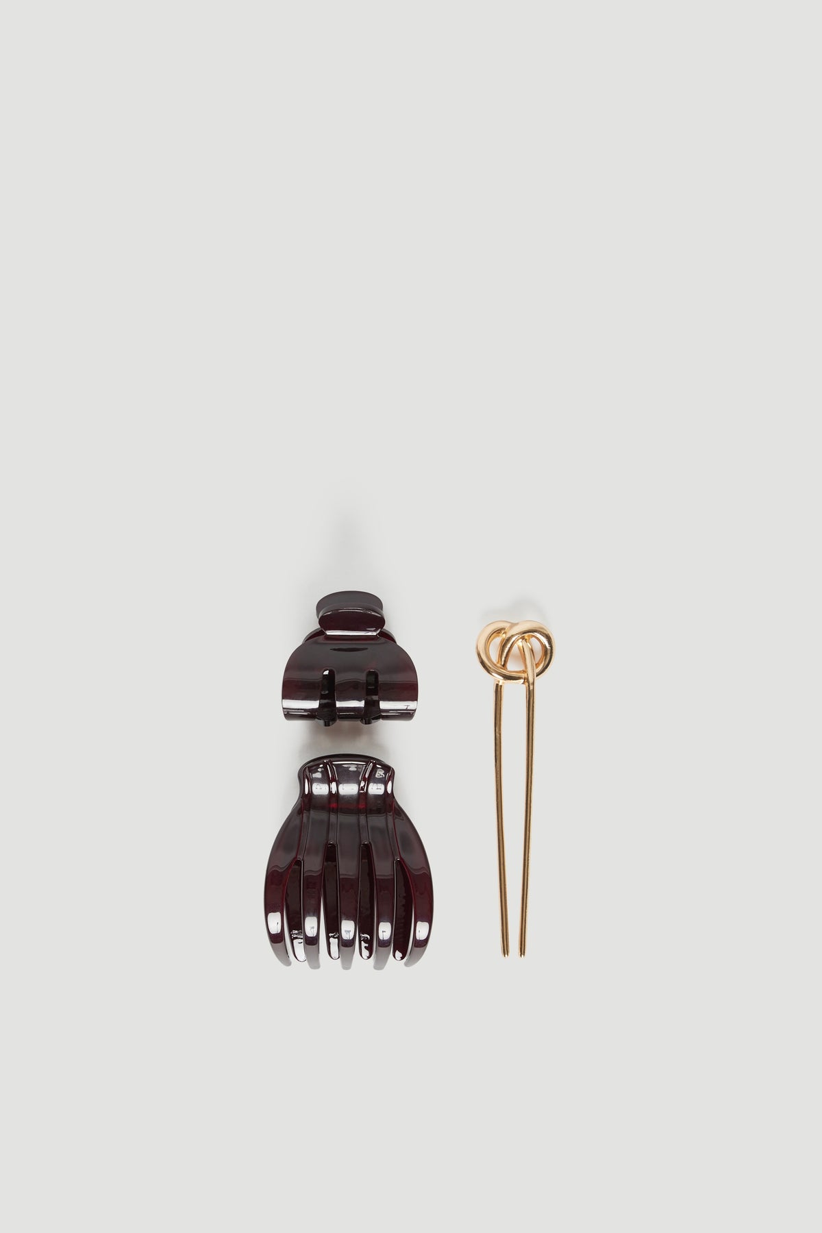 Three-piece acetate hair accessory set with two tortoiseshell claw clips and a gold hair tie