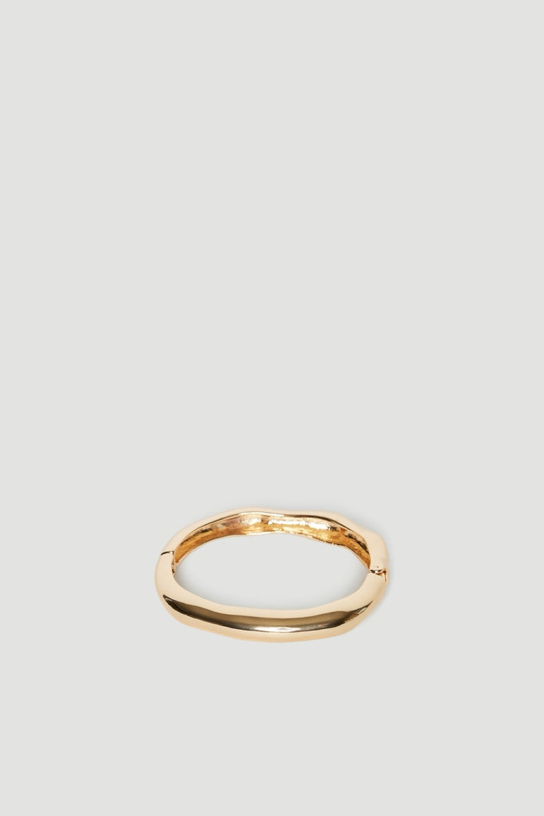 Shiny gold hinge bangle with an uneven textured finish and oval shape
