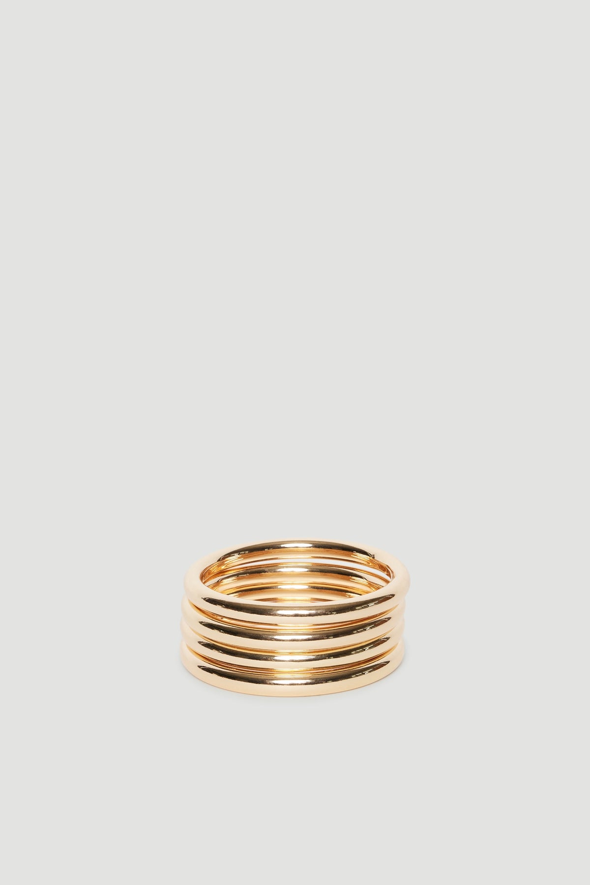 Stacked gold tone bangles with thick bands