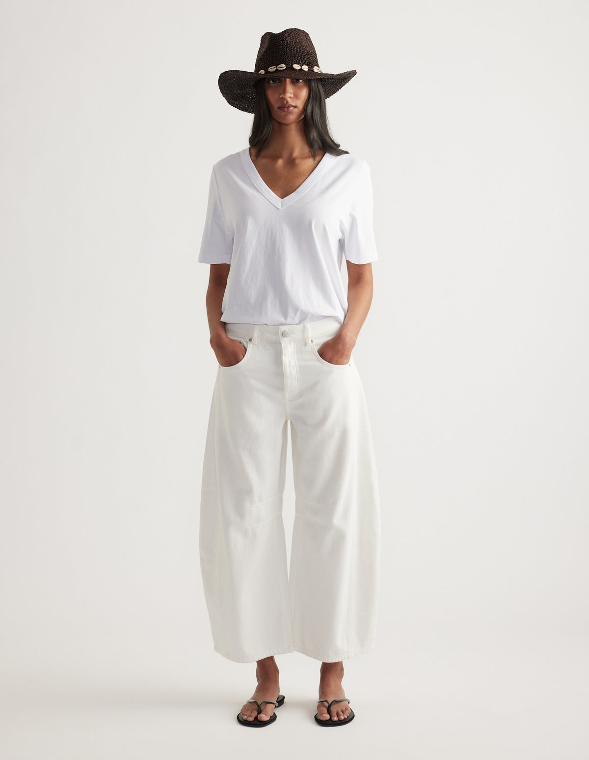 Model wearing a chocolate brown cowboy hat with shell detailing, white tee and wide leg trousers
