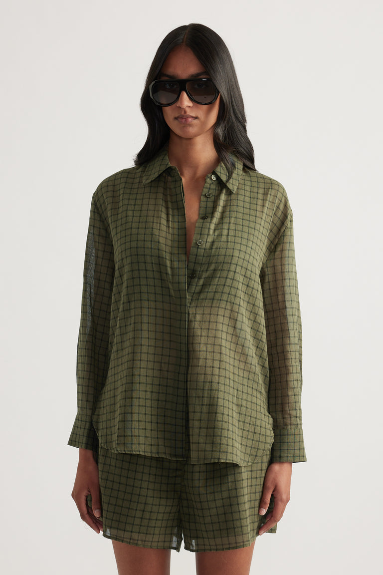 Model wearing an olive green checked oversized shirt with matching shorts