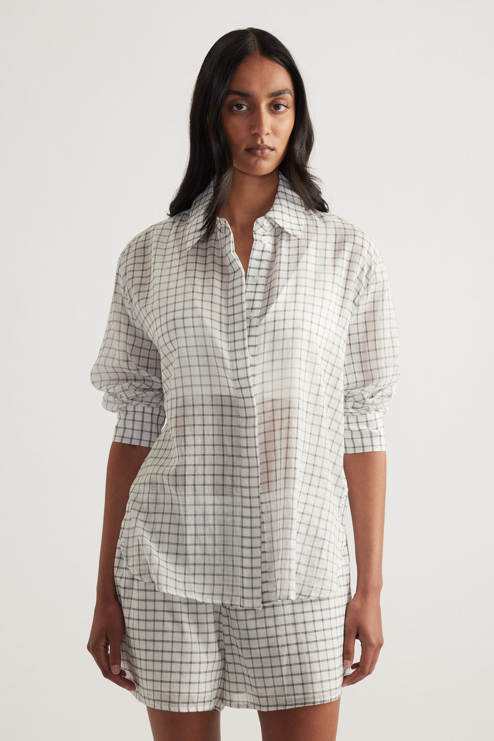 Model wearing an oversized cream checked shirt with button front and matching shorts