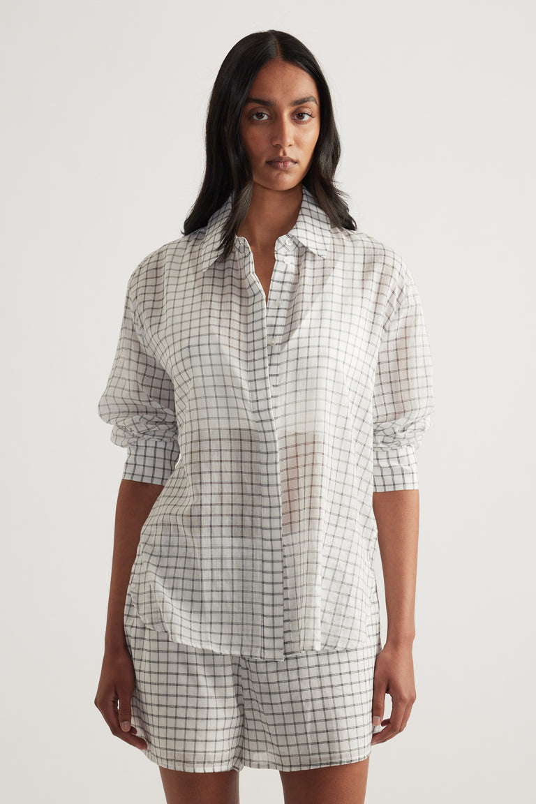 Model wearing an oversized cream checked shirt with button front and matching shorts