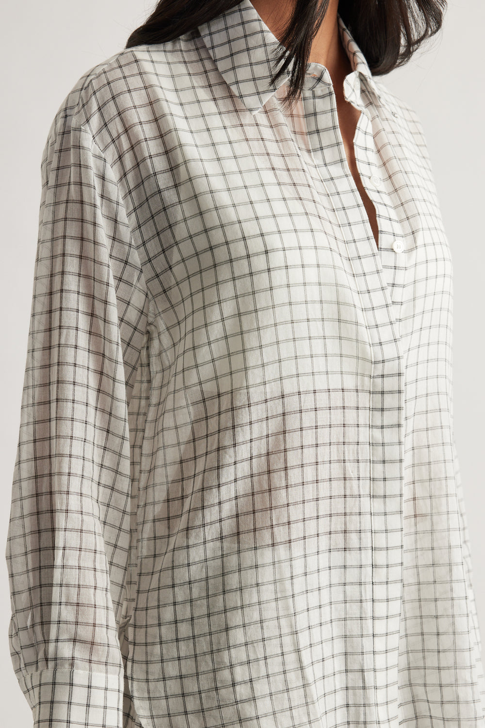 Model wearing an oversized cream check shirt with a collared neckline, long sleeves and button front