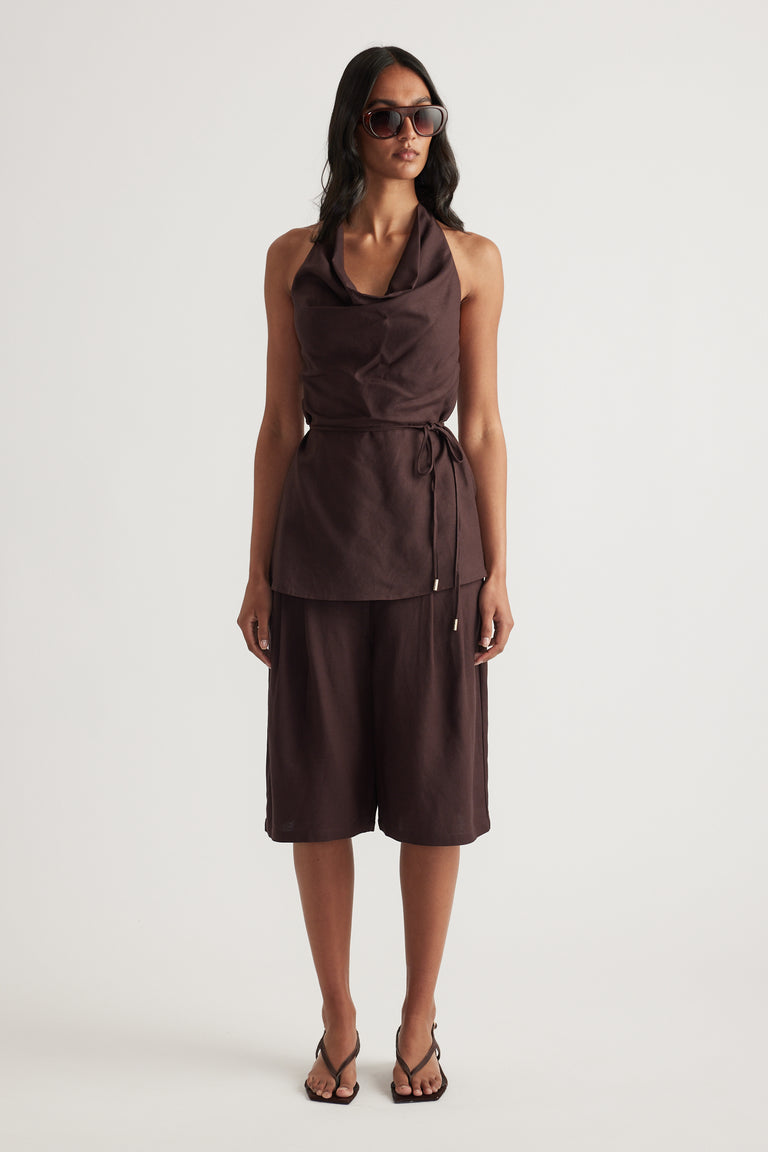 Model wearing a chocolate brown cowl neck halter top with a waist tie and matching knee length shorts
