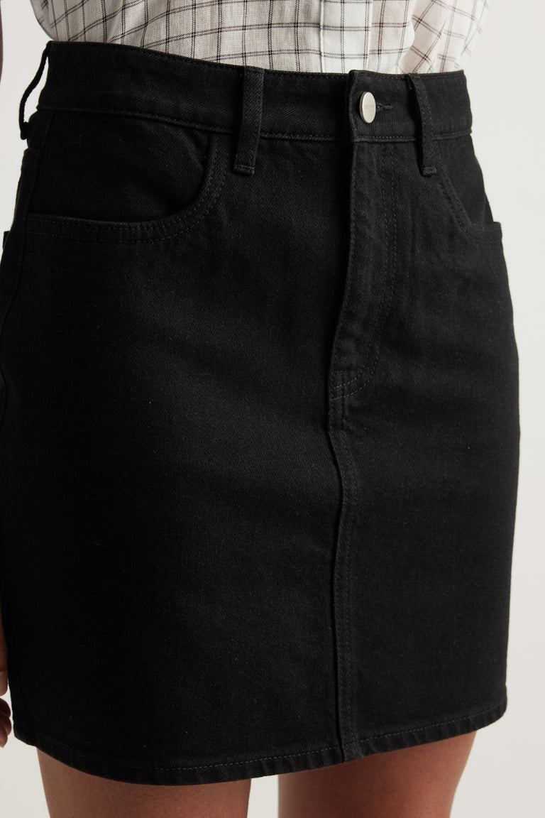Black high rise denim mini skirt with front pockets, button fly and above the knee length