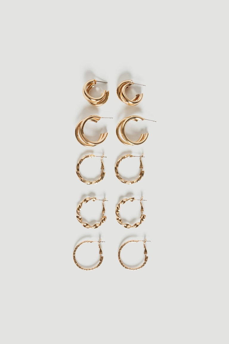 Five pairs of small gold hoop earrings in varying sizes with smooth and textured finishes