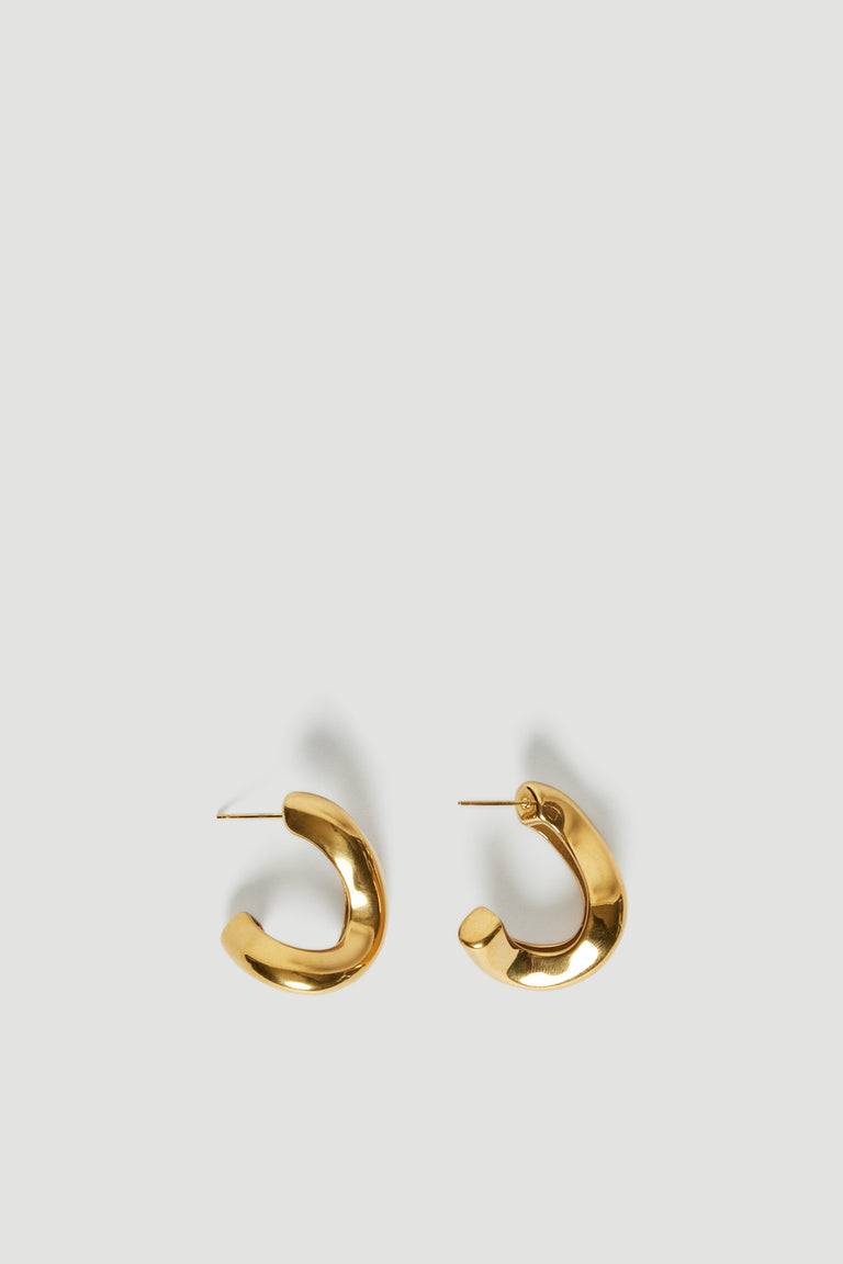 Gold abstract wavy hoop earrings displayed on a light background