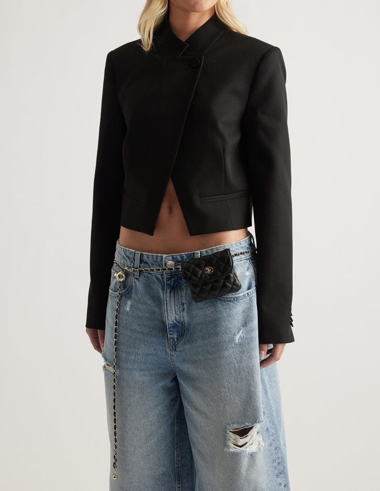 Black quilted mini bag belt with gold hardware styled over relaxed ripped jeans and a cropped black blazer
