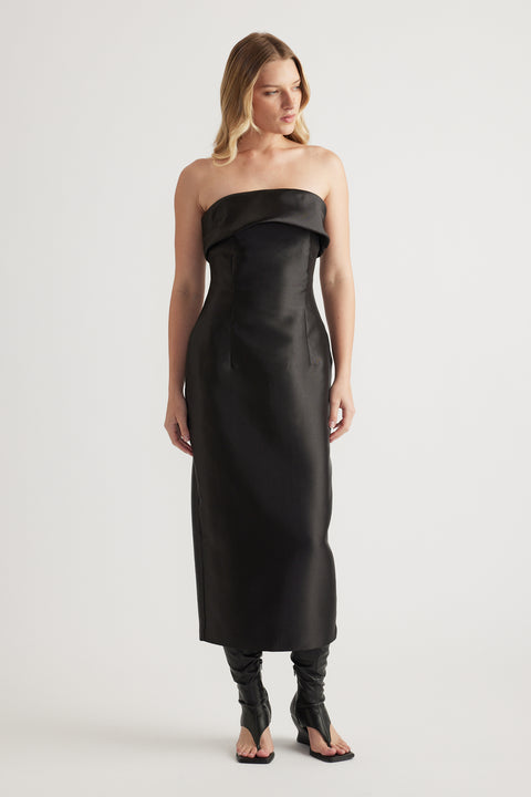 Woman wearing a black strapless fitted midi dress with a folded neckline and structured finish