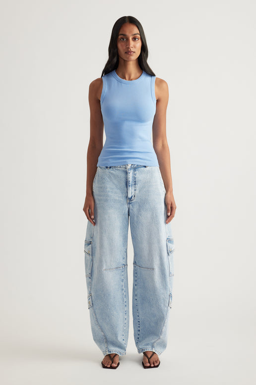 Woman wearing a fitted blue ribbed tank top with wide leg light wash cargo jeans