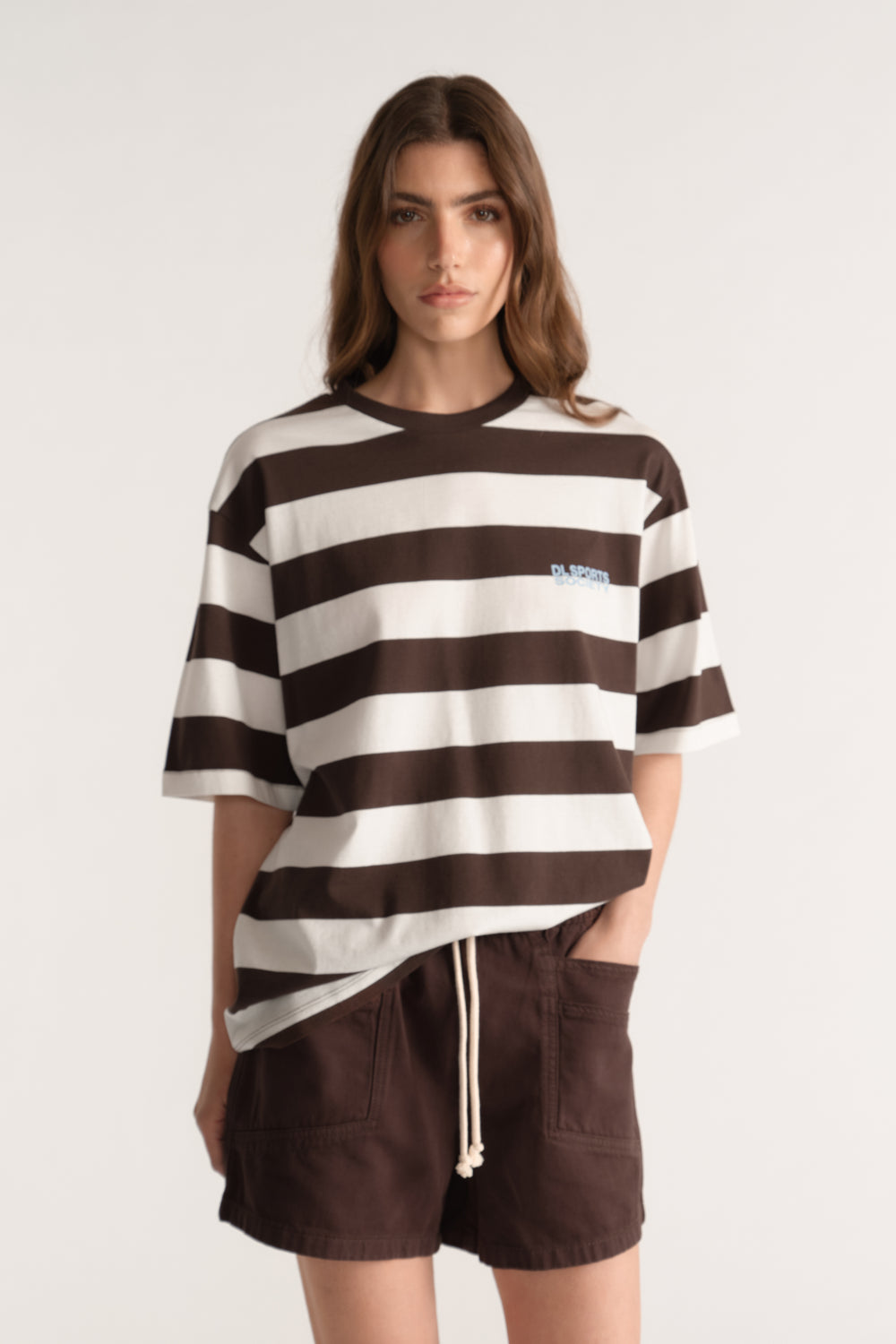 Woman wearing a relaxed brown and cream striped tee with dark brown drawstring shorts