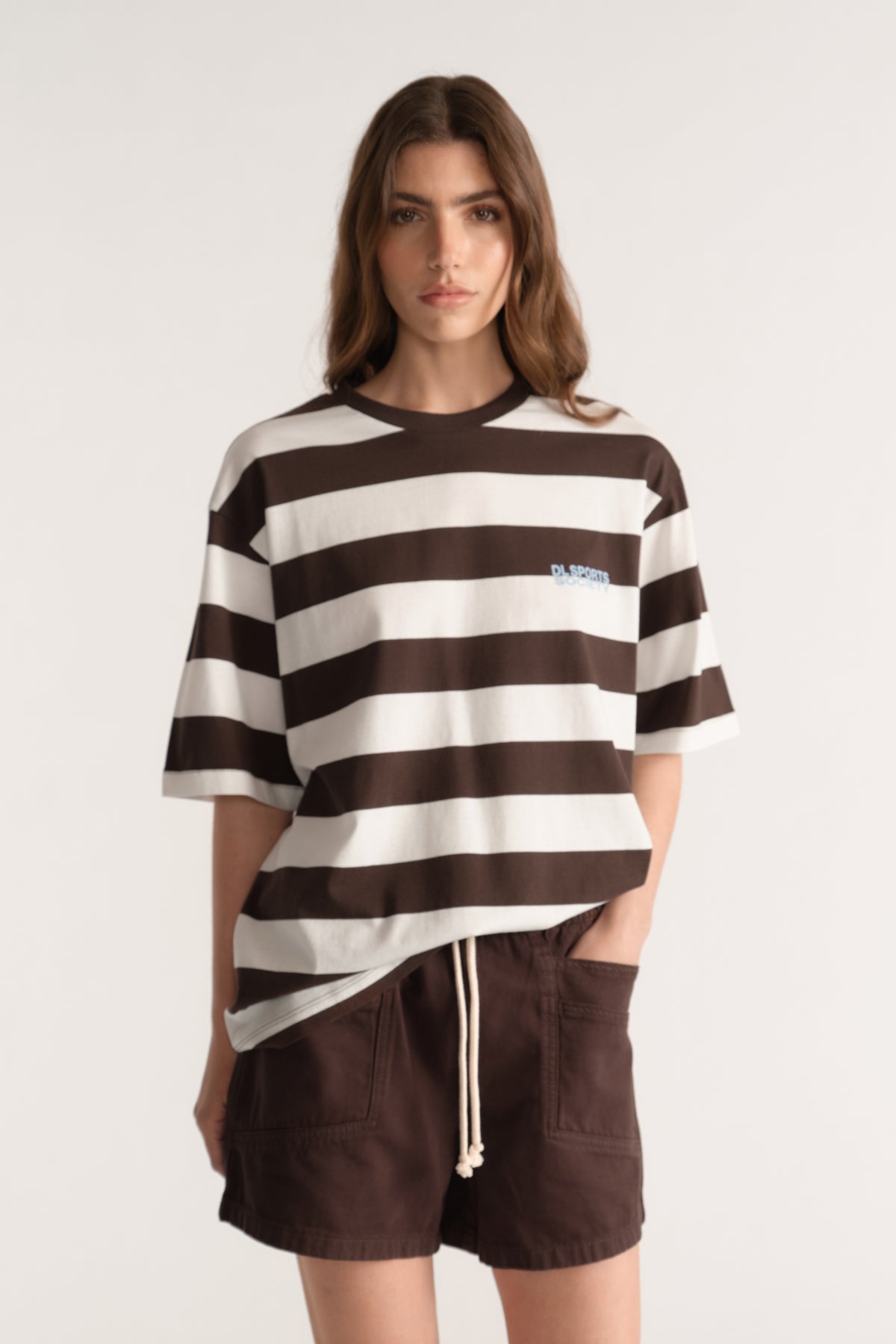 Woman wearing a relaxed brown and cream striped tee with dark brown drawstring shorts