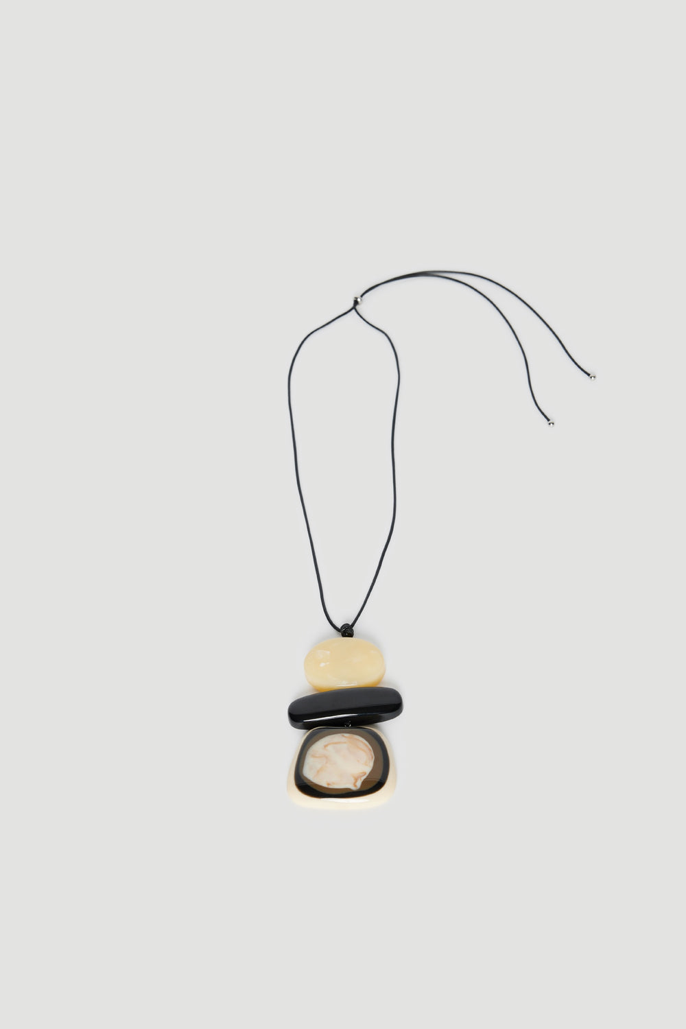Statement cord necklace with three large pebble beads in black, cream and yellow