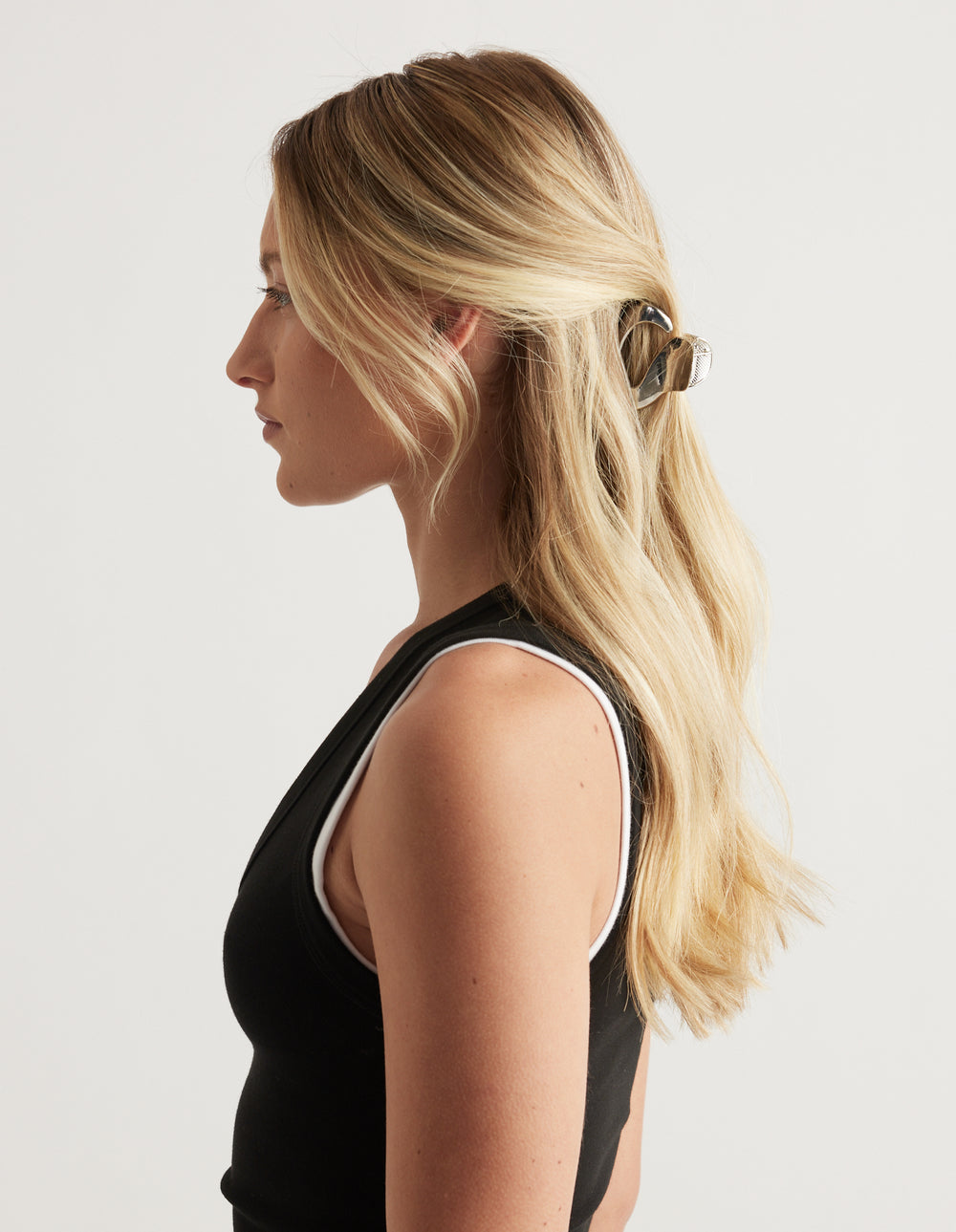 Woman with long blonde hair styled in a small high shine oval claw clip