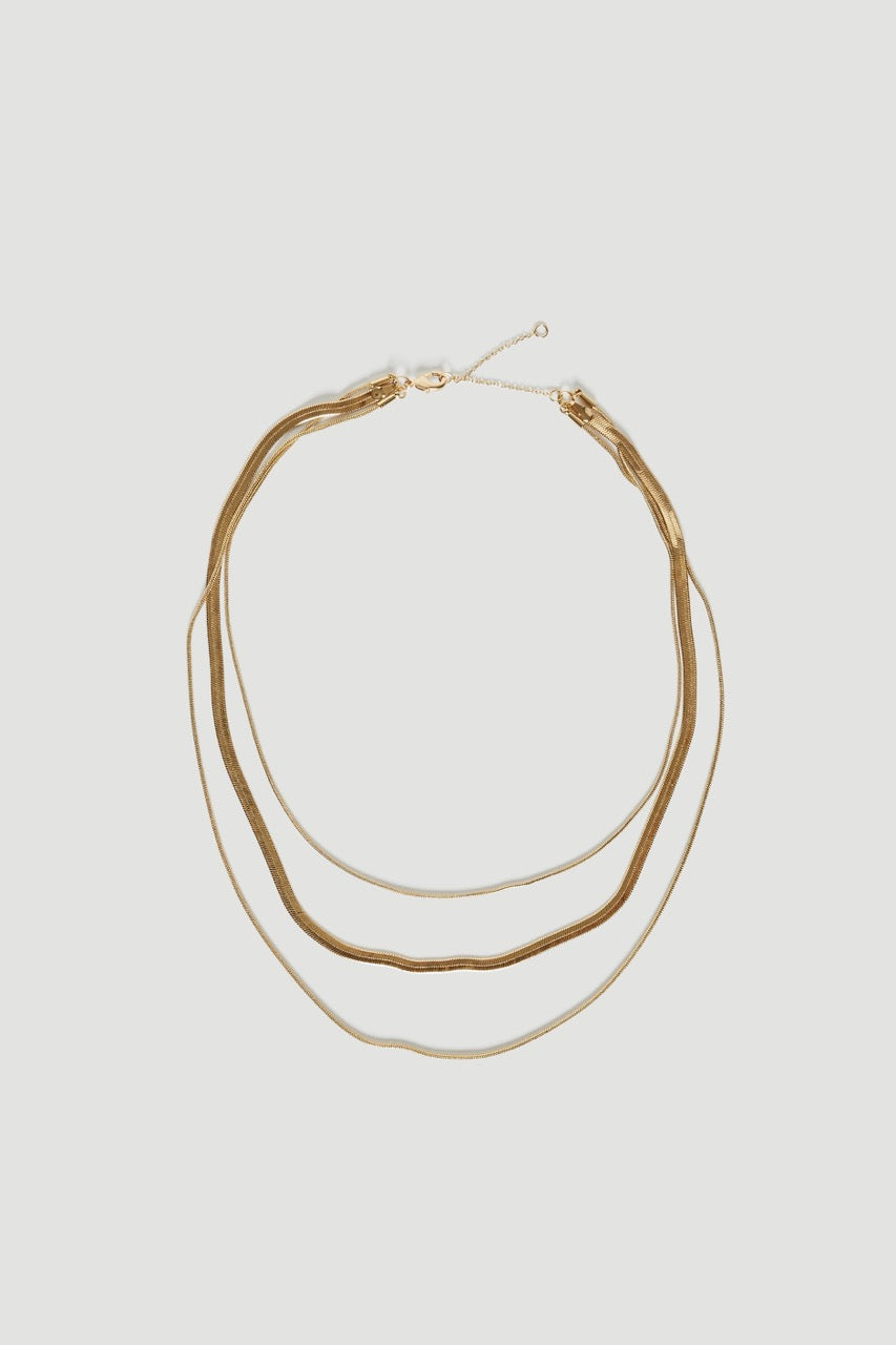 Layered gold necklace with three delicate chains and a lobster clasp