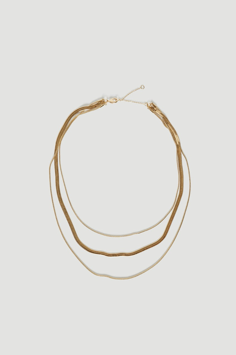 Layered gold necklace with three delicate chains and a lobster clasp