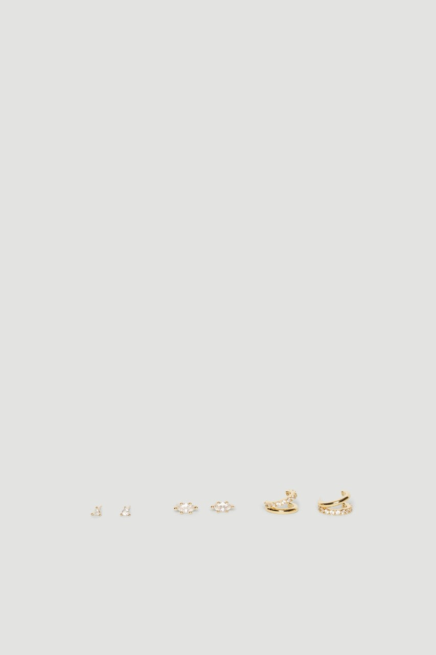 Three pairs of gold tone diamante earrings with delicate studs, floral clusters and huggie hoops