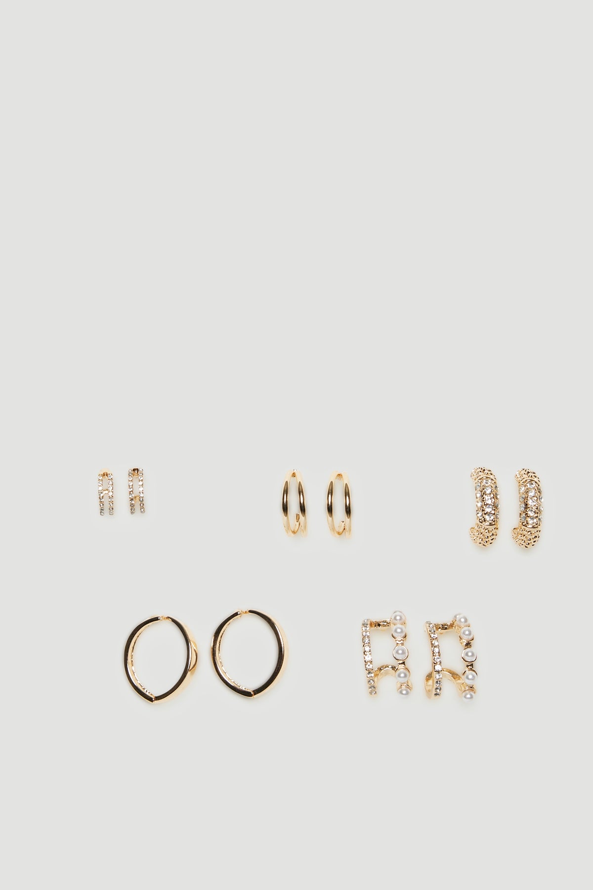 Five pairs of gold hoop earrings in assorted sizes and textured finishes