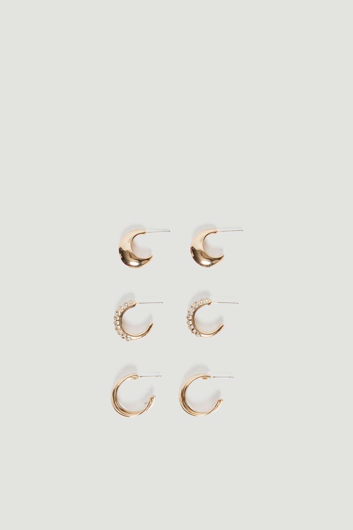 Three pairs of gold mini hoop earrings featuring smooth and diamante detailing