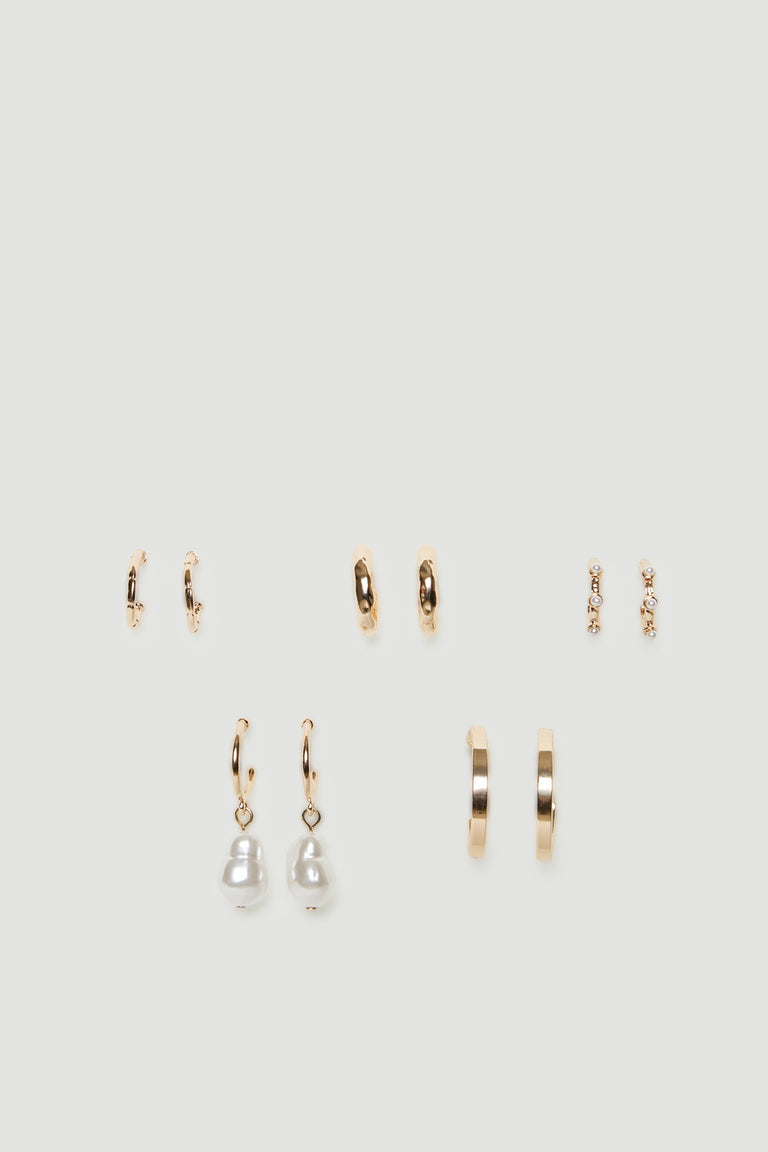 Five pairs of gold tone mini hoop earrings with textured finishes and pearl details