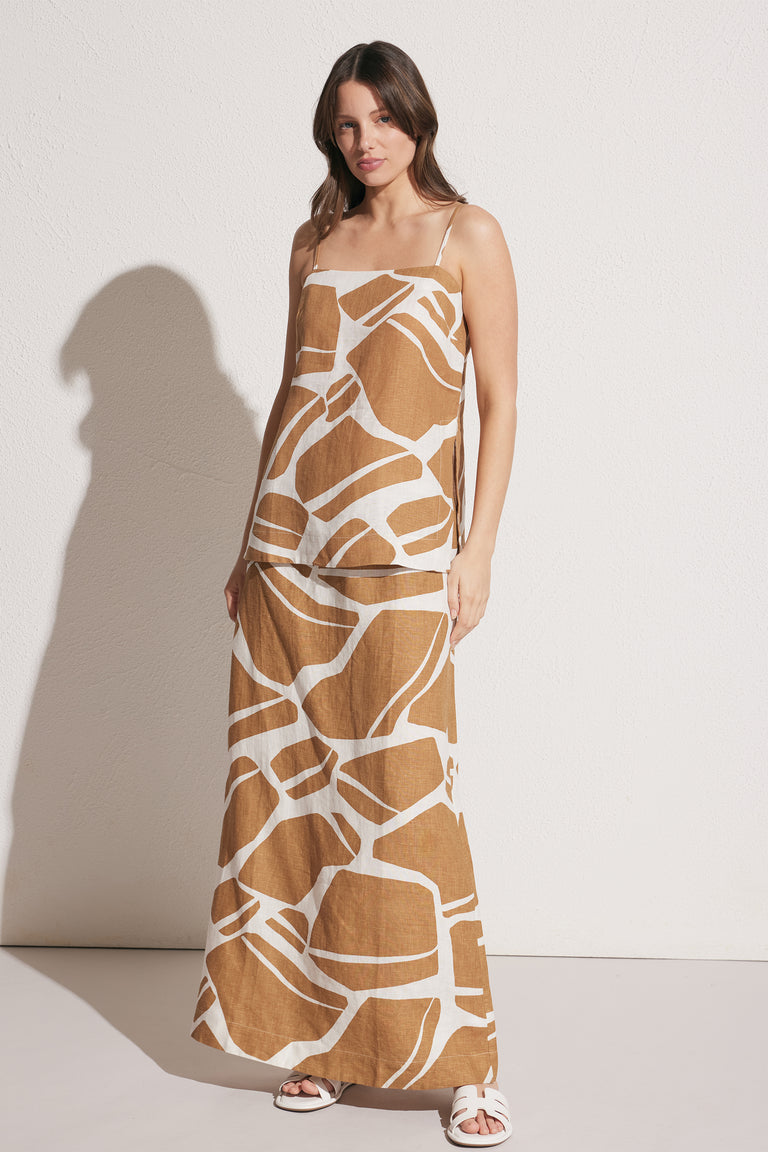 Woman wearing a brown and white abstract print longline linen cami with thin straps and square neckline