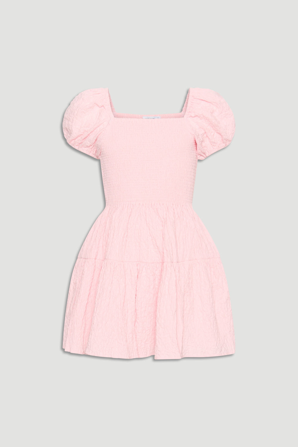 Light pink textured mini dress with smocked bodice, square neckline, and puffed short sleeves for girls.